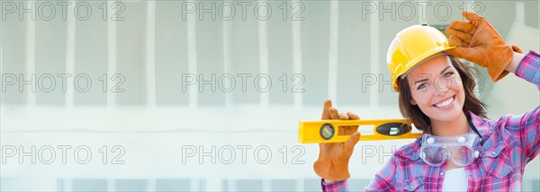 Female contractor wearing hard hat against dywall banner background with ladder
