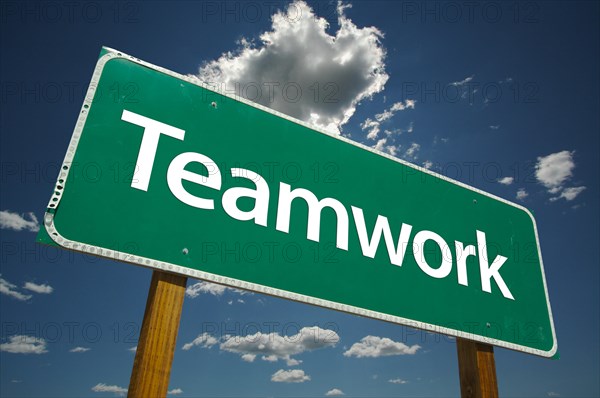 Teamwork road sign with dramatic blue sky and clouds