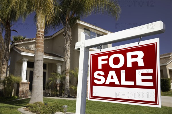For sale real estate sign in front of house