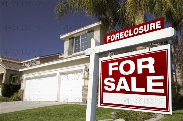 Foreclosure for sale real estate sign in front of house