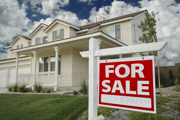 Home for sale real estate sign in front of new house