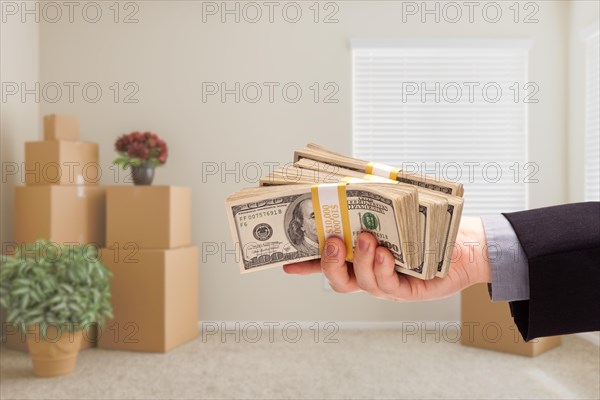 Man handing over cash in room with packed moving boxes