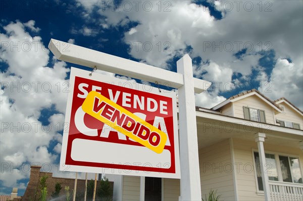 Red and yellow spanish sold home for real estate sale sign