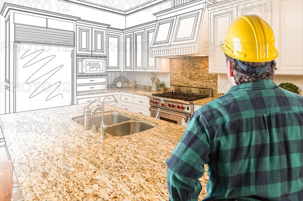 Male contractor with hard hat looking at custom kitchen drawing photo combination on white