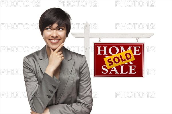Ethnic woman in front of sold home for sale real estate sign isolated on a white background
