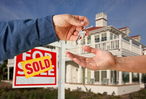 Handing over the house keys in front of a beautiful new home
