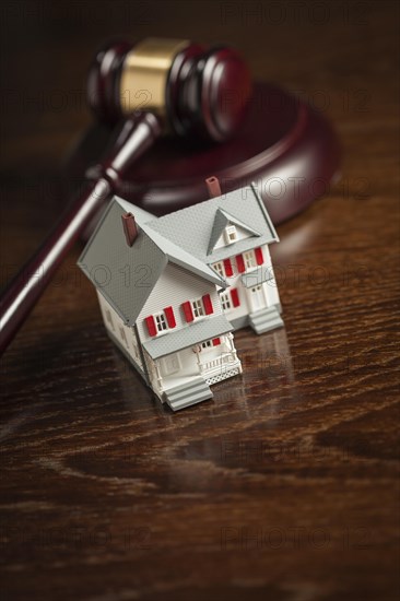 Gavel and small model house on wooden table