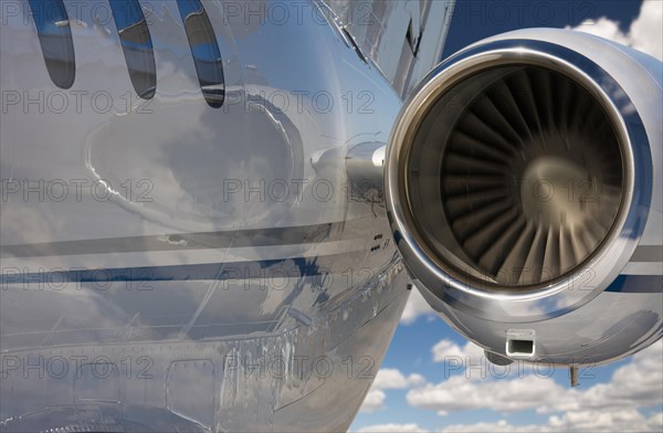 Private jet and engine abstract over clouds and sky
