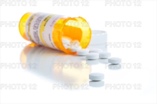 Non-Proprietary medicine prescription bottle and spilled pills isolated on a white background