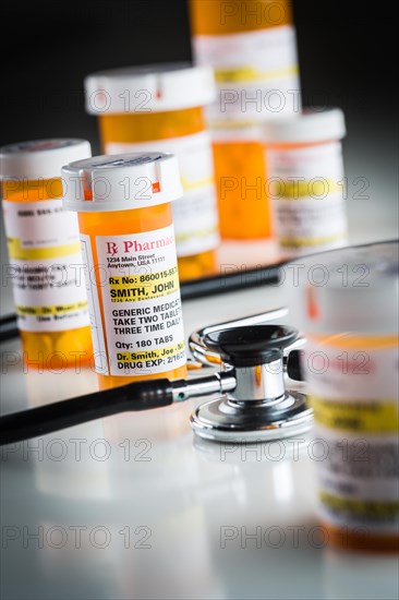 Several non-proprietary medicine prescription bottles abstract with stethoscope