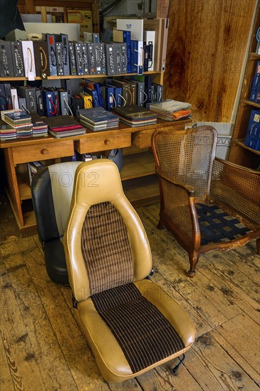 Antique chair and car seat in a saddlery in Allgaeu