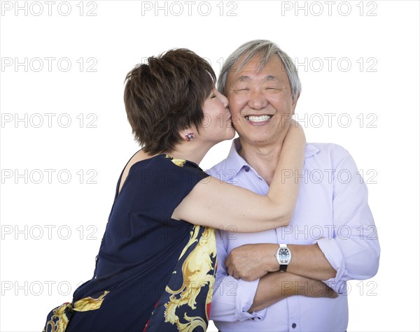 Attractive affectionate senior chinese couple isolated on a white background