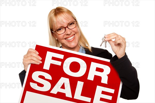 Attractive blonde holding keys & for sale sign isolated on a white background