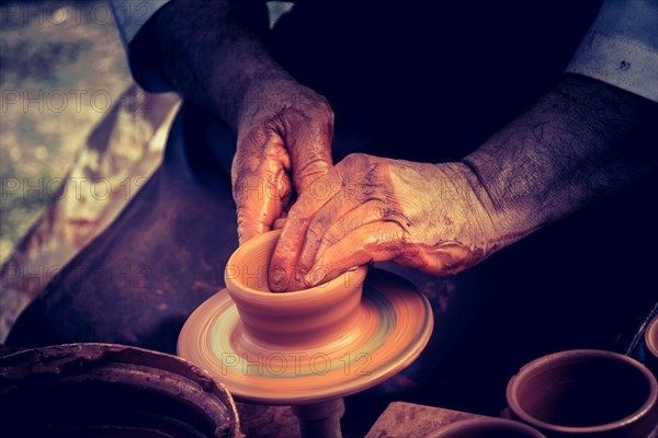 Potter`s hands shaping up the clay of the pot