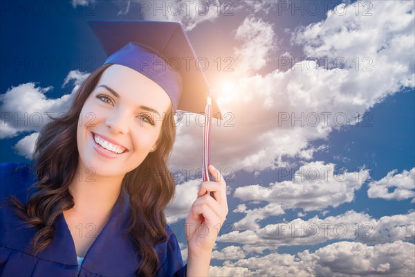 Happy graduating mixed-race woman in cap and gown