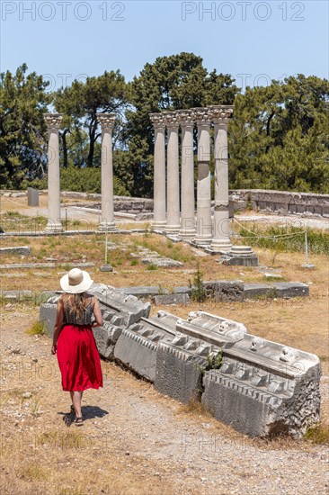Young woman with dress in front of ruins with columns