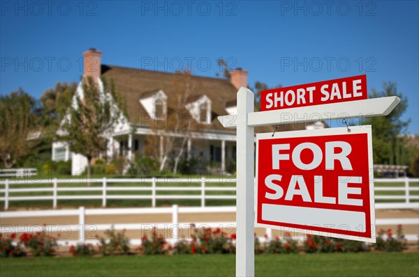 Short sale home for sale real estate sign in front of new house