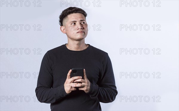 Thoughtful man with cell phone in hand