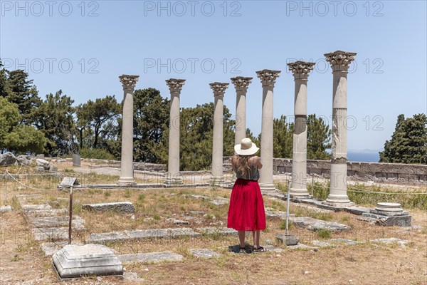 Young woman with dress in front of ruins with columns