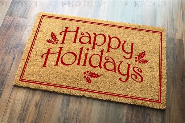 Happy holidays christmas tad welcome mat on wood floor background