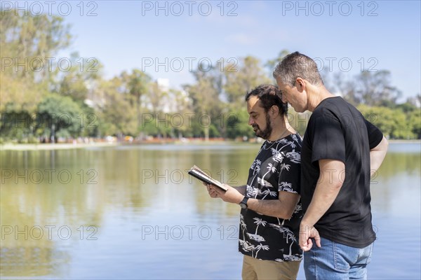 Couple of mature men reading in a lake
