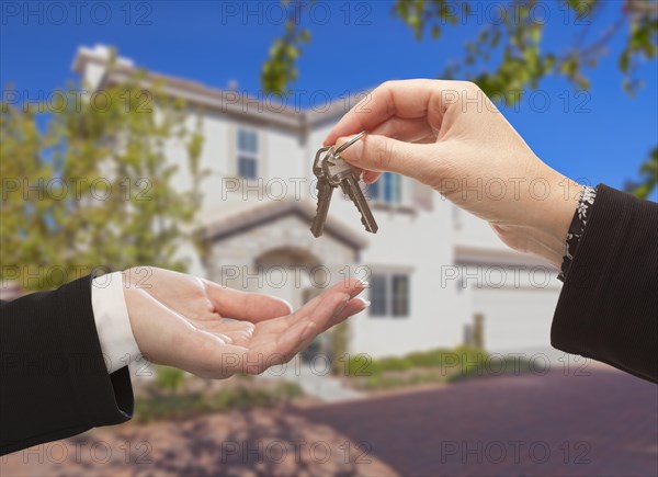 Handing over the new house keys with home in the background