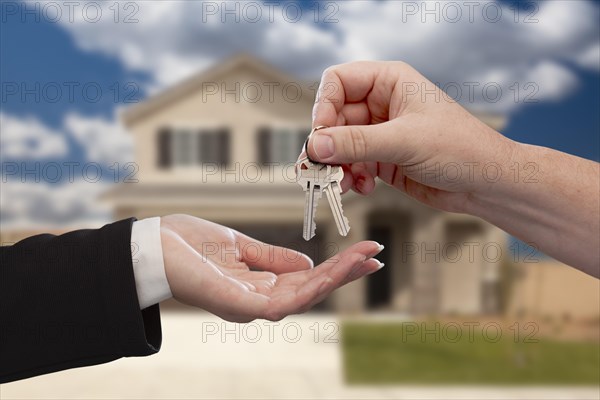 Handing over the house keys in front of a beautiful new home