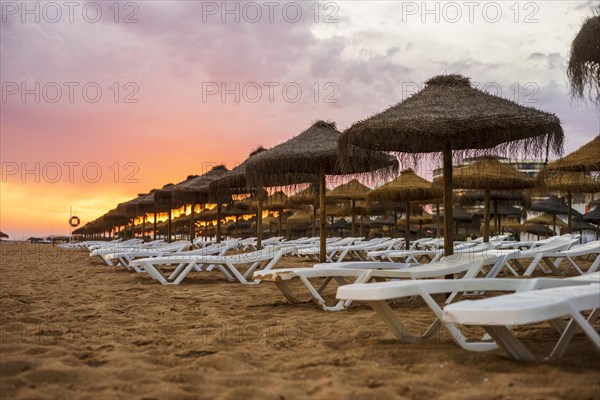 Beautiful colorful sunset over sun beds and umbrellas in Vilamoura