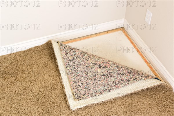Pulled back carpet and underlay in room of house