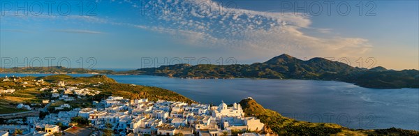 Panorama of Plaka village on Milos island with traditional greek white houses on sunset