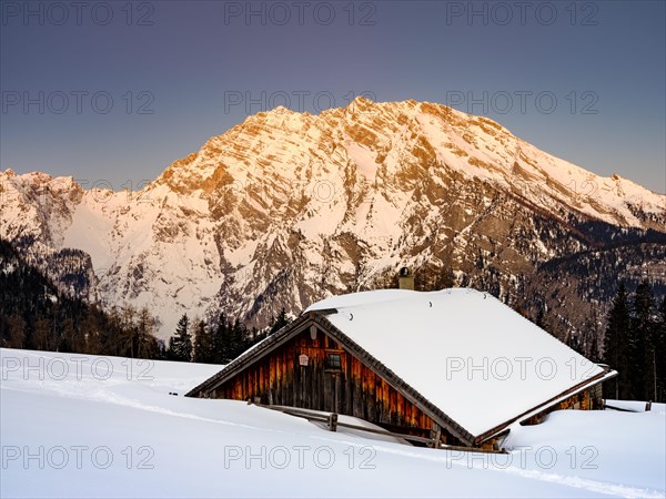 Snowy Priesbergalm in front of Watzmann east face at sunrise