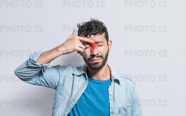 Young man with pain touching nose. A person with nasal bridge pain