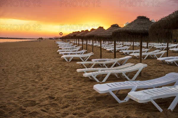 Beautiful colorful sunset over sun beds and umbrellas in Vilamoura
