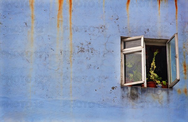 Verwitterte Fassade mit geoeffneten Fenster