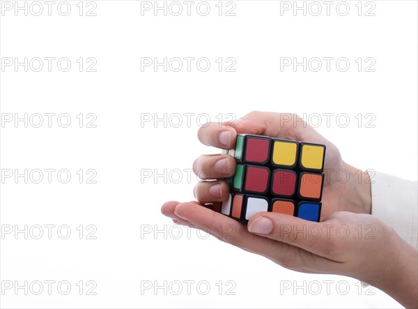 Child holding a Rubik's cube in hand on a white background