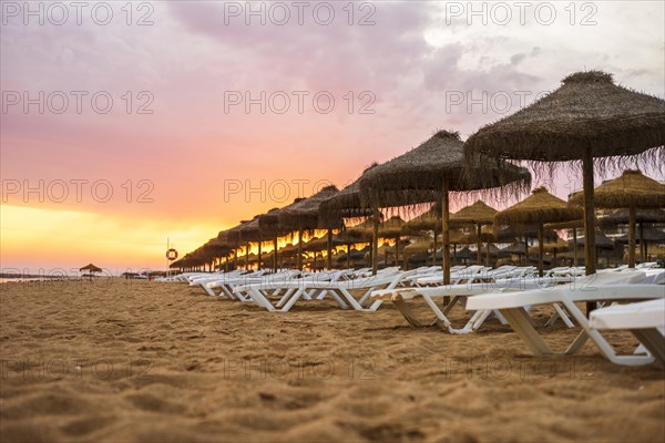 Beautiful colorful sunset over sun beds and umbrellas in Vilamoura