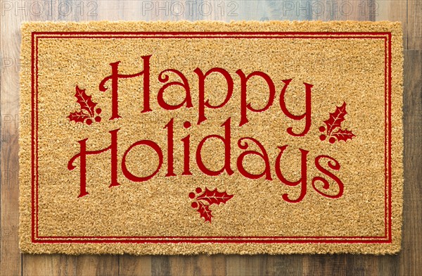 Happy holidays christmas tad welcome mat on wood floor background