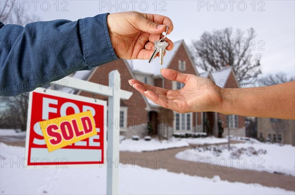 Handing over the house keys in front of a beautiful new home