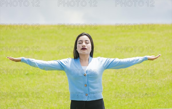 A girl spreading her arms in the field