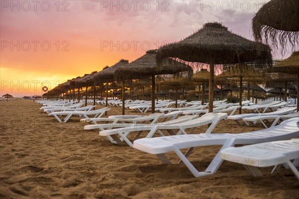 Beautiful colorful sunset over sun beds and umbrellas in Vilamoura