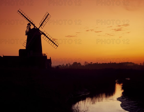 Windmill silhouetted at sunset