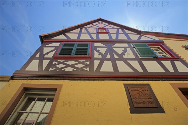 View upwards to the gable of a half-timbered house with shutters in Oestrich