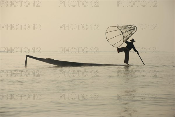 Traditional fisherman with fish trap in boat