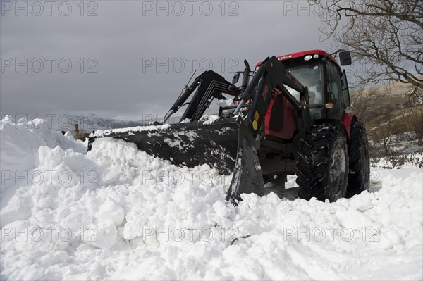 Zetor tractor with loader clears snow from blocked country road after snowstorm