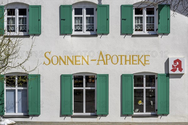 Fassade mit gruenen Fensterlaeden