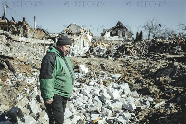 Serhiy Melnyk stands on the ruins of his house in the residential district of Bohunia