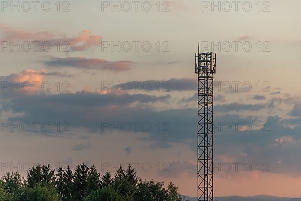 Telecom antenna in countryside in summer at sunset. Alsace