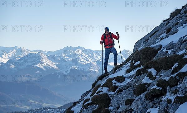 Mountaineers on the rocky summit ridge with the first snow in autumn