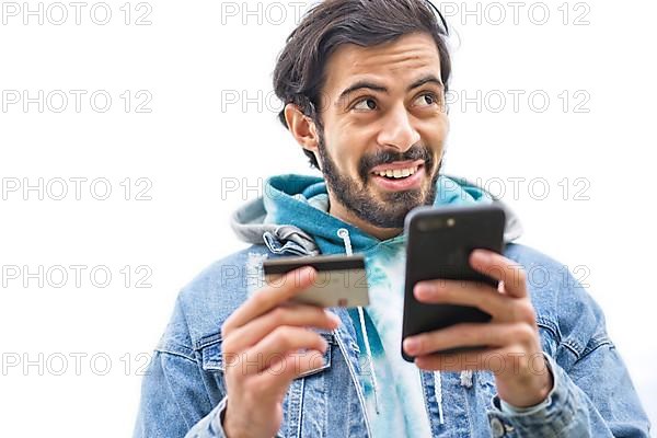 Latin man using credit card to make online payment on smartphone. mixed-race man using cellphone for shopping online. Guy using smart phone to check credit card transactions from app. White background...