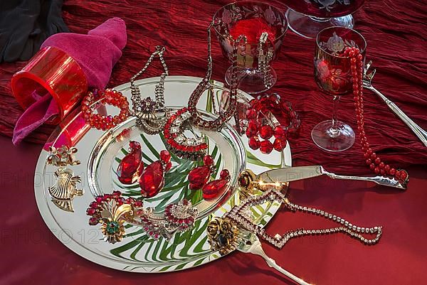 Rhinestone jewellery and accessories decorated on a silver plate and red cloth, Bavaria